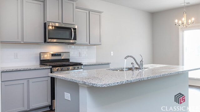 kitchen featuring gray cabinets, sink, light stone counters, and stainless steel appliances