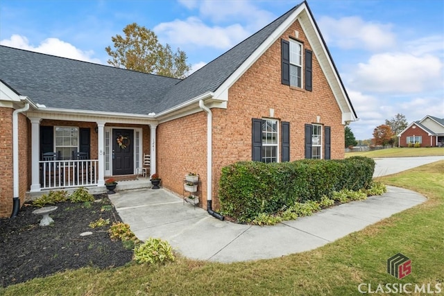 view of front of home with covered porch and a front lawn