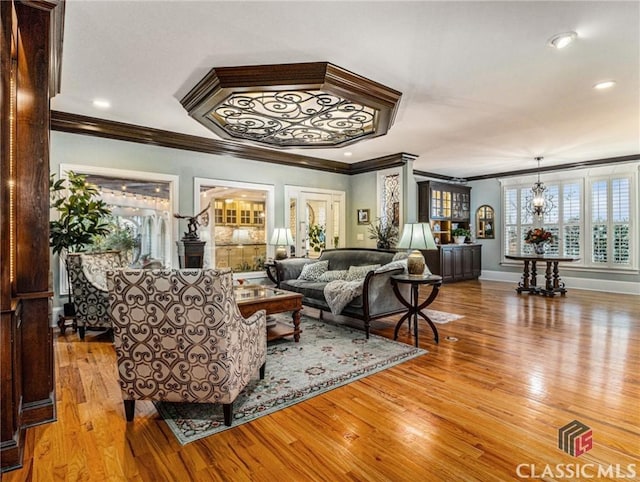 living room featuring ornamental molding, wood finished floors, baseboards, and recessed lighting
