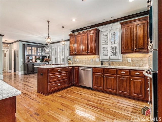 kitchen featuring crown molding, stainless steel appliances, a chandelier, a sink, and a peninsula