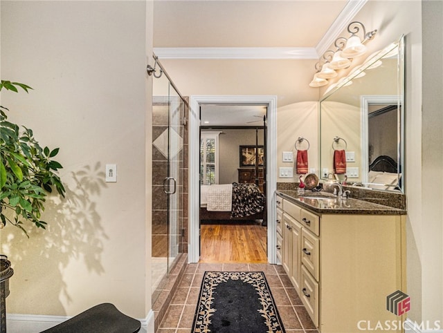 bathroom featuring vanity, hardwood / wood-style flooring, crown molding, and a shower with shower door