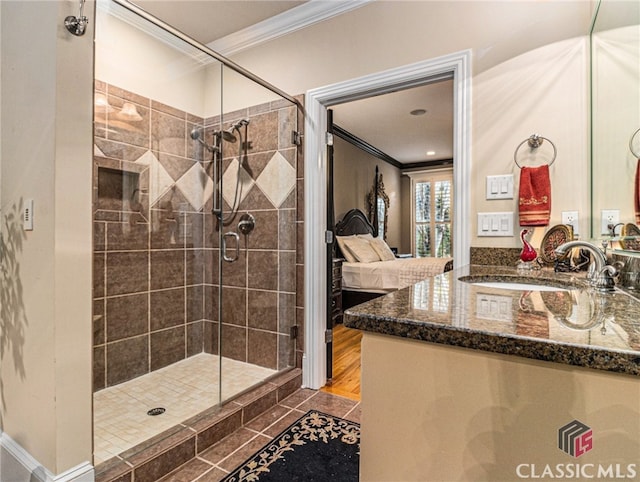 bathroom with hardwood / wood-style floors, vanity, an enclosed shower, and ornamental molding