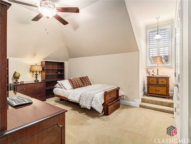 bedroom with ceiling fan, light colored carpet, and vaulted ceiling