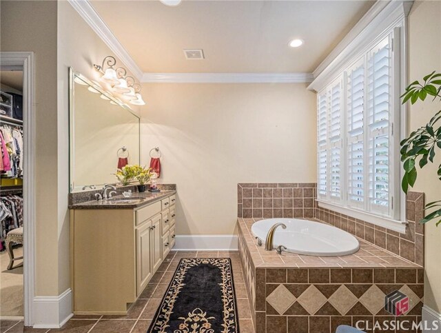 full bath featuring ornamental molding, a stall shower, two vanities, a garden tub, and tile patterned floors