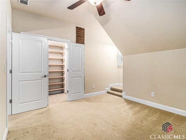 office area featuring vaulted ceiling, a ceiling fan, and light colored carpet