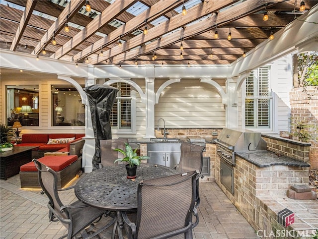 view of patio featuring exterior kitchen, a grill, a pergola, and sink