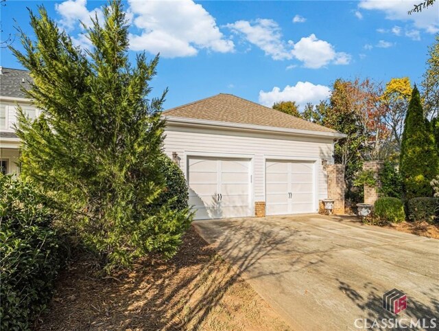 garage featuring concrete driveway