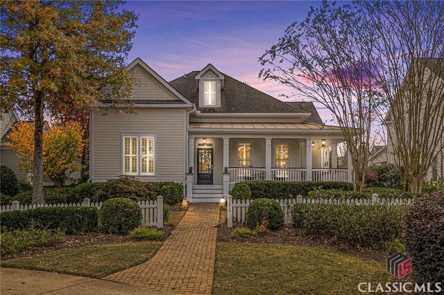 view of front of home featuring covered porch, a standing seam roof, and a shingled roof