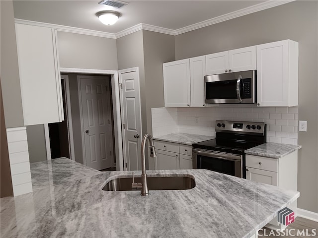 kitchen featuring light stone countertops, appliances with stainless steel finishes, and white cabinets