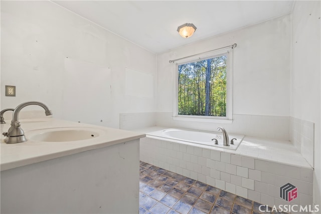 bathroom with sink, tiled bath, and tile patterned flooring