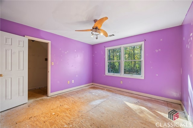 unfurnished bedroom featuring a walk in closet and ceiling fan