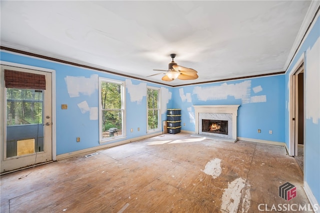 unfurnished living room with ceiling fan, crown molding, and a premium fireplace