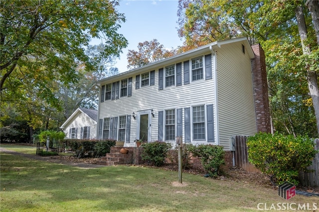 colonial-style house featuring a front yard