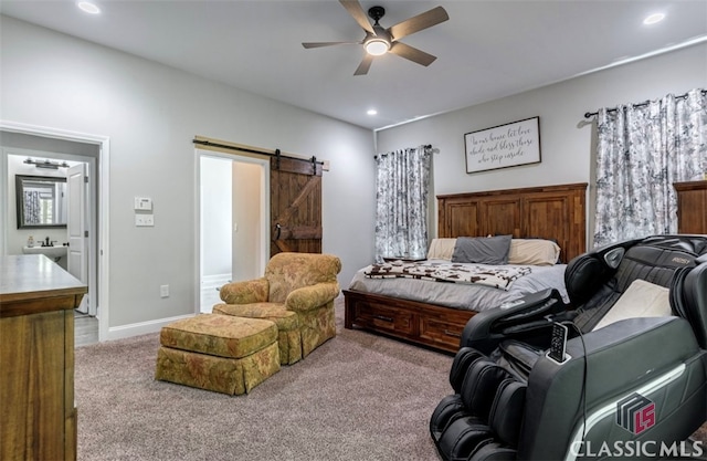 bedroom featuring ensuite bathroom, a barn door, carpet floors, and ceiling fan