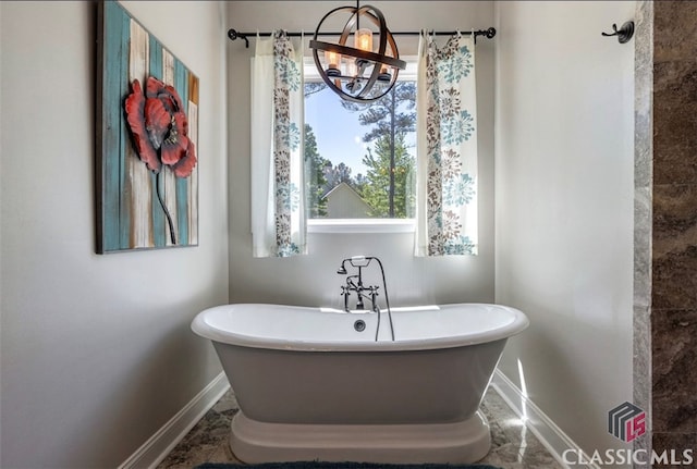 bathroom featuring a washtub, a notable chandelier, and a wealth of natural light