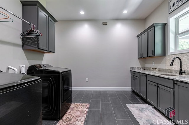 laundry area with sink, washer and clothes dryer, and cabinets