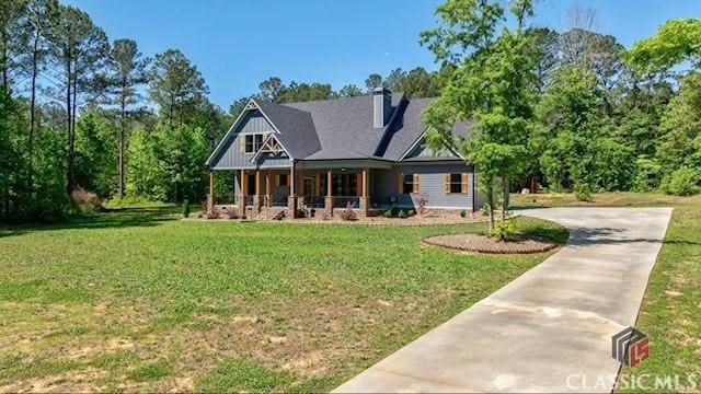 rear view of house featuring a porch and a lawn