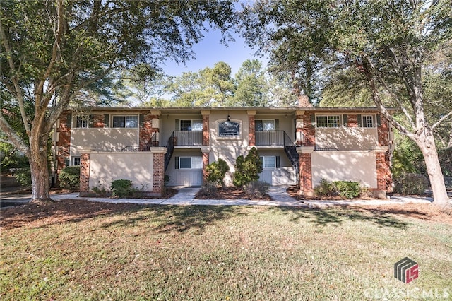 view of front of property with a balcony and a front yard