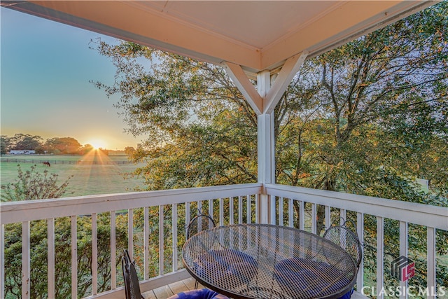 deck at dusk featuring a rural view