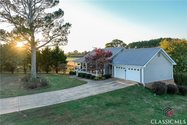 view of front of property with a garage and a lawn