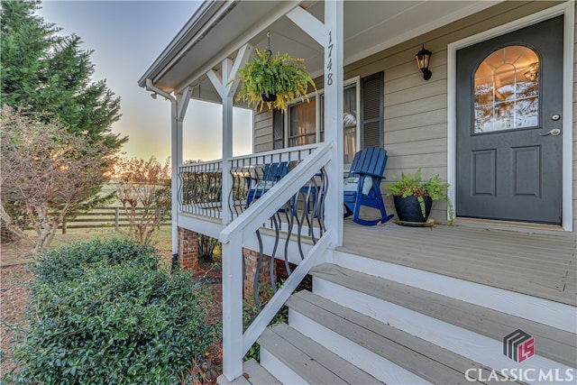 exterior entry at dusk featuring a porch