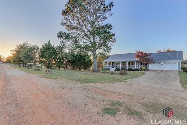 view of front of home with a garage and a lawn