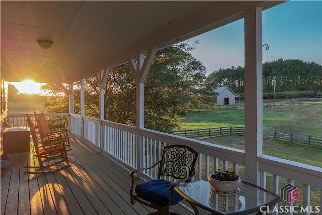 deck at dusk featuring a yard