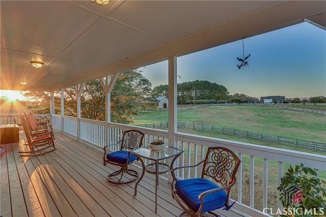 deck at dusk with a lawn and a rural view