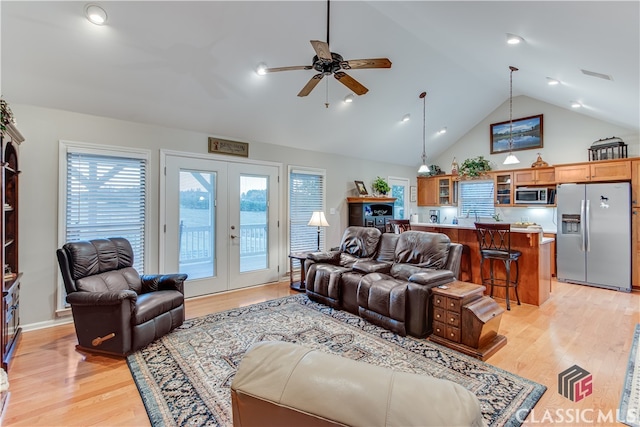 living room with french doors, light hardwood / wood-style floors, ceiling fan, and high vaulted ceiling