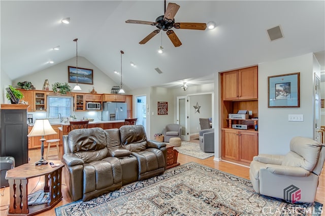 living room featuring ceiling fan, light hardwood / wood-style flooring, and high vaulted ceiling