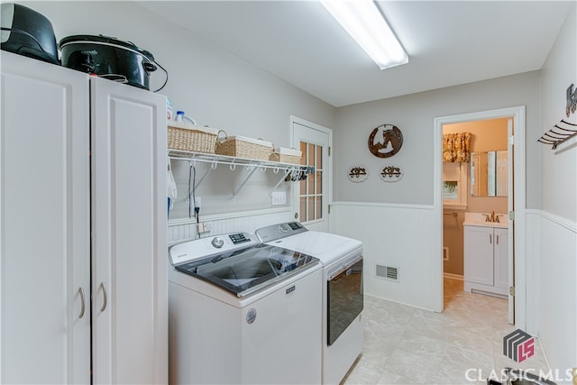 clothes washing area with separate washer and dryer and sink