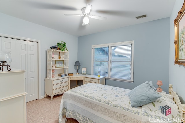 carpeted bedroom featuring ceiling fan and a closet