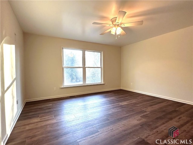 empty room with ceiling fan and dark hardwood / wood-style floors