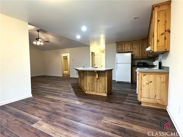 kitchen featuring ceiling fan, a kitchen island, dark hardwood / wood-style flooring, and white appliances