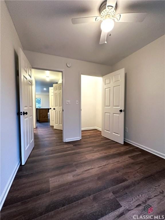 unfurnished bedroom with ceiling fan and dark hardwood / wood-style flooring