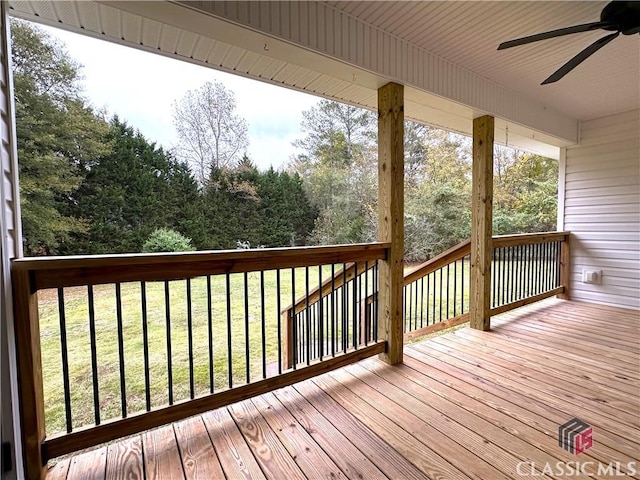 wooden deck with a lawn and ceiling fan