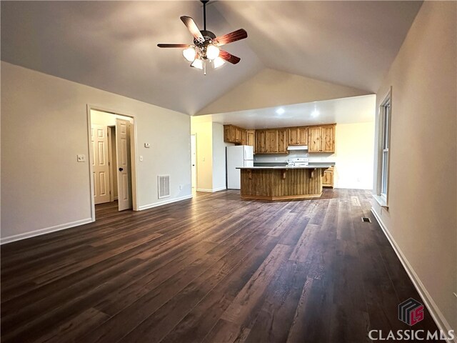 unfurnished living room featuring ceiling fan, dark hardwood / wood-style flooring, and vaulted ceiling