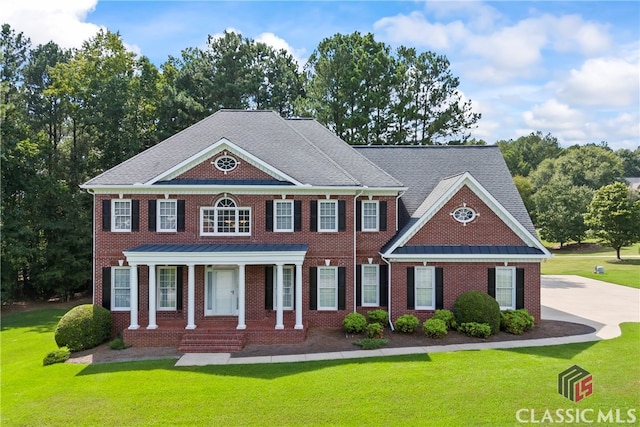 colonial inspired home featuring a front lawn