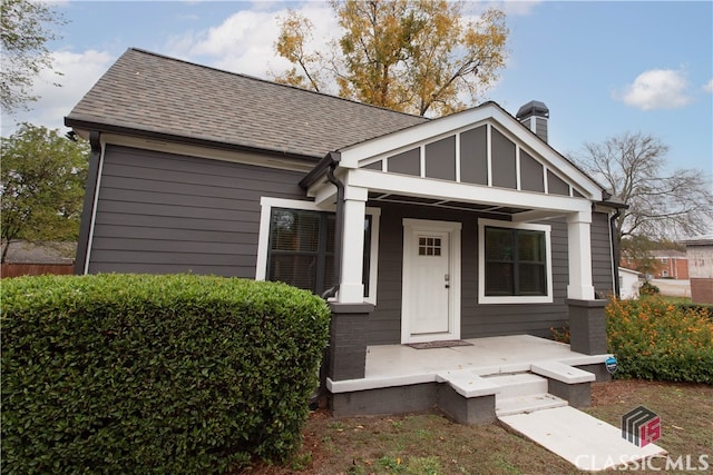 view of front of house featuring a shingled roof, a porch, and board and batten siding