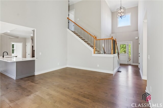 entryway with hardwood / wood-style flooring, sink, a high ceiling, and a chandelier