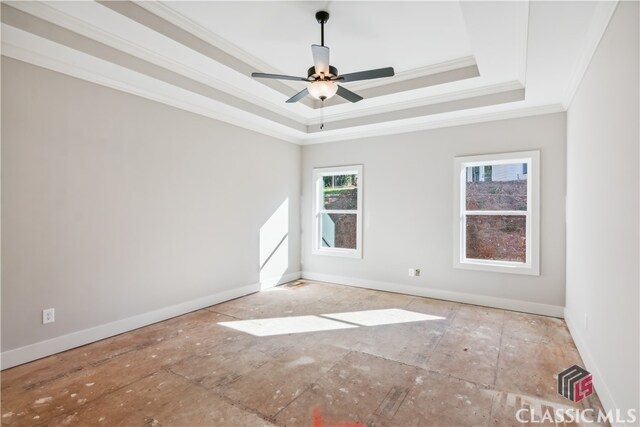 spare room with a raised ceiling, ceiling fan, and ornamental molding