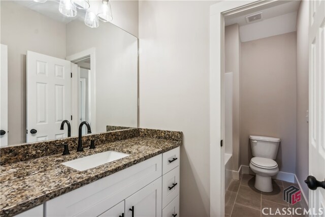 bathroom featuring tile patterned flooring, vanity, and toilet