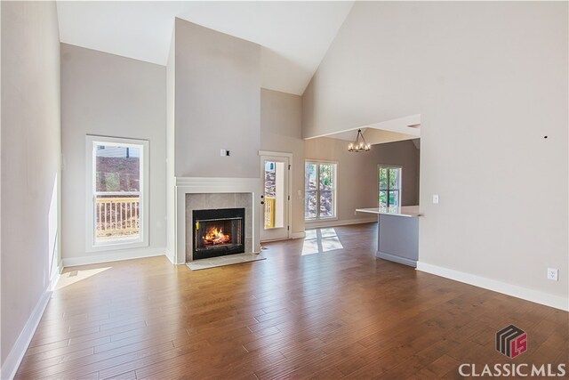 unfurnished living room featuring wood-type flooring, high vaulted ceiling, and plenty of natural light