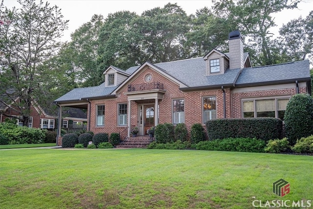 cape cod house featuring a front lawn