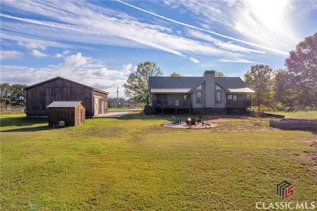 view of yard featuring a shed, a garage, and an outdoor fire pit