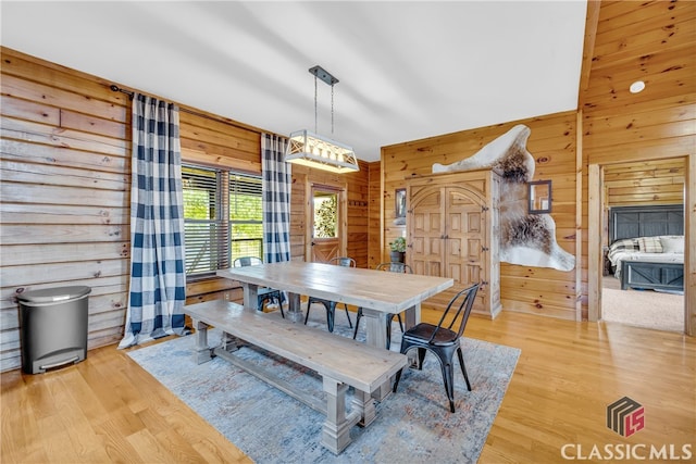 dining room featuring light hardwood / wood-style floors and wood walls