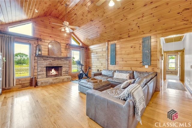 living room with plenty of natural light, wooden ceiling, wooden walls, and light hardwood / wood-style flooring