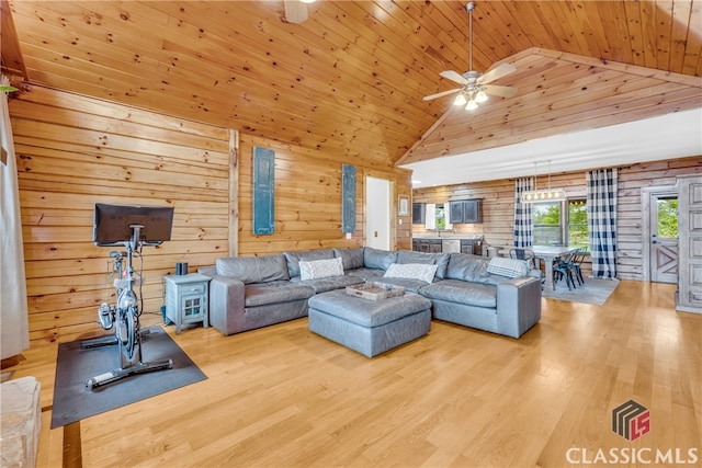 living room with light wood-type flooring, wooden ceiling, and wooden walls