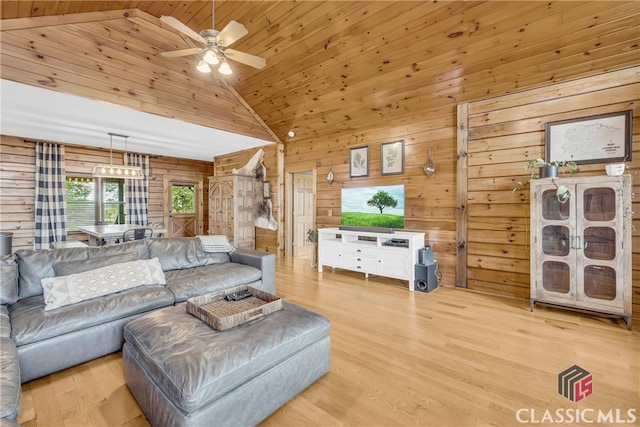 living room featuring light hardwood / wood-style flooring, wooden walls, and wooden ceiling