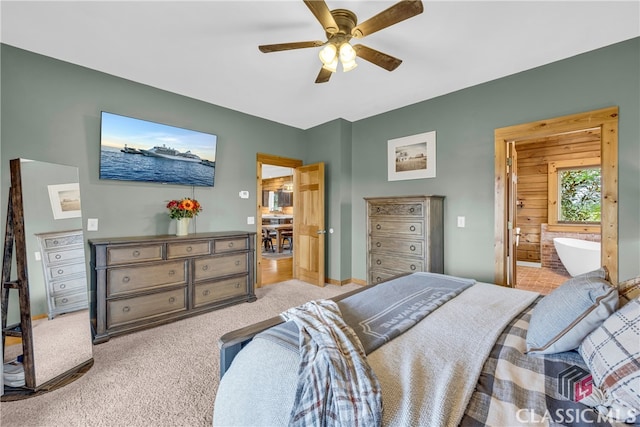 bedroom with ceiling fan, ensuite bath, and light carpet